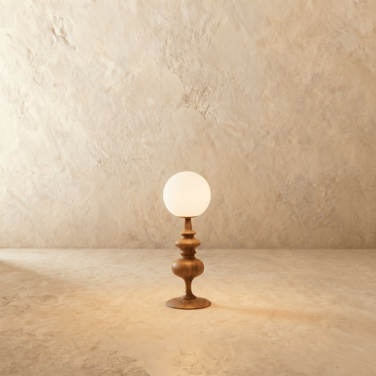 Clérachic table lamp in walnut glowing warm, a turned wood base beneath a round opal glass globe.