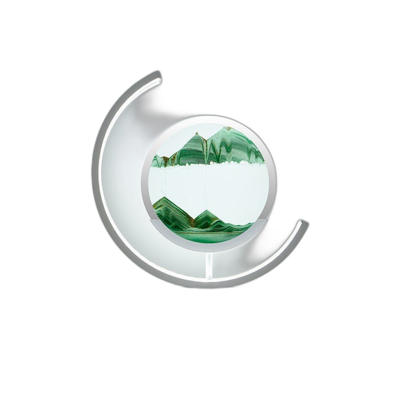 Close view of the moving sand art lamp with green sand forming layered mountains in the glass disc