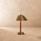 Clérachic table lamp in vintage brass shown from another angle, light spilling beneath the cone shade.
