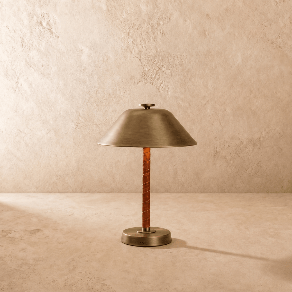 Clérachic table lamp in vintage brass shown from another angle, light spilling beneath the cone shade.