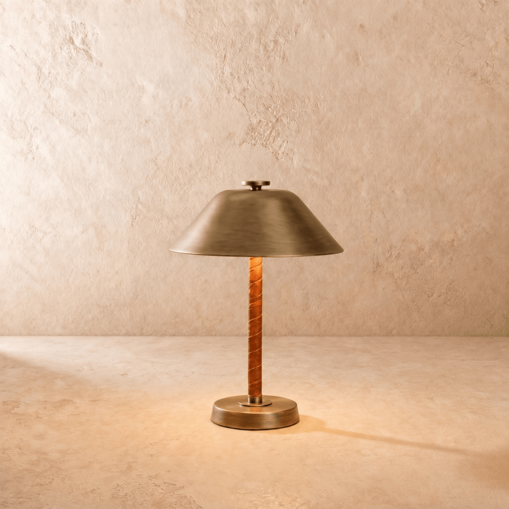 Clérachic table lamp in vintage brass, a cone metal shade over a cognac leather-wrapped stem.