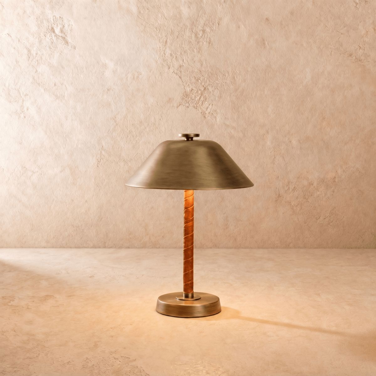 Clérachic table lamp in vintage brass, a cone metal shade over a cognac leather-wrapped stem.