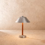 This Clérachic table lamp in chrome, a cone metal shade over a cognac leather-wrapped stem.