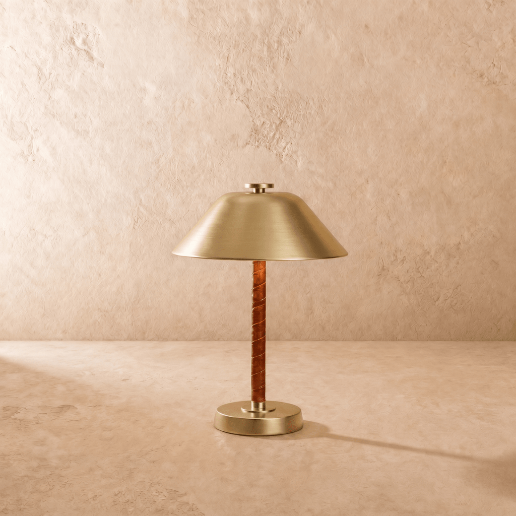 Clérachic table lamp in brushed brass viewed close, showing the round base and leather-wrapped stem.