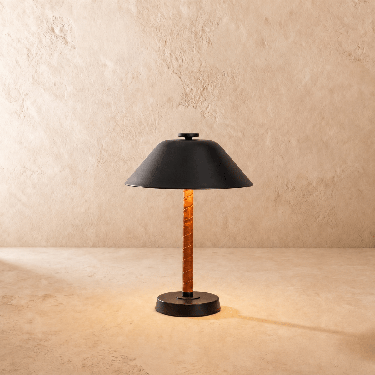 Clérachic table lamp in matte black, the cone metal shade set above a leather-wrapped stem.