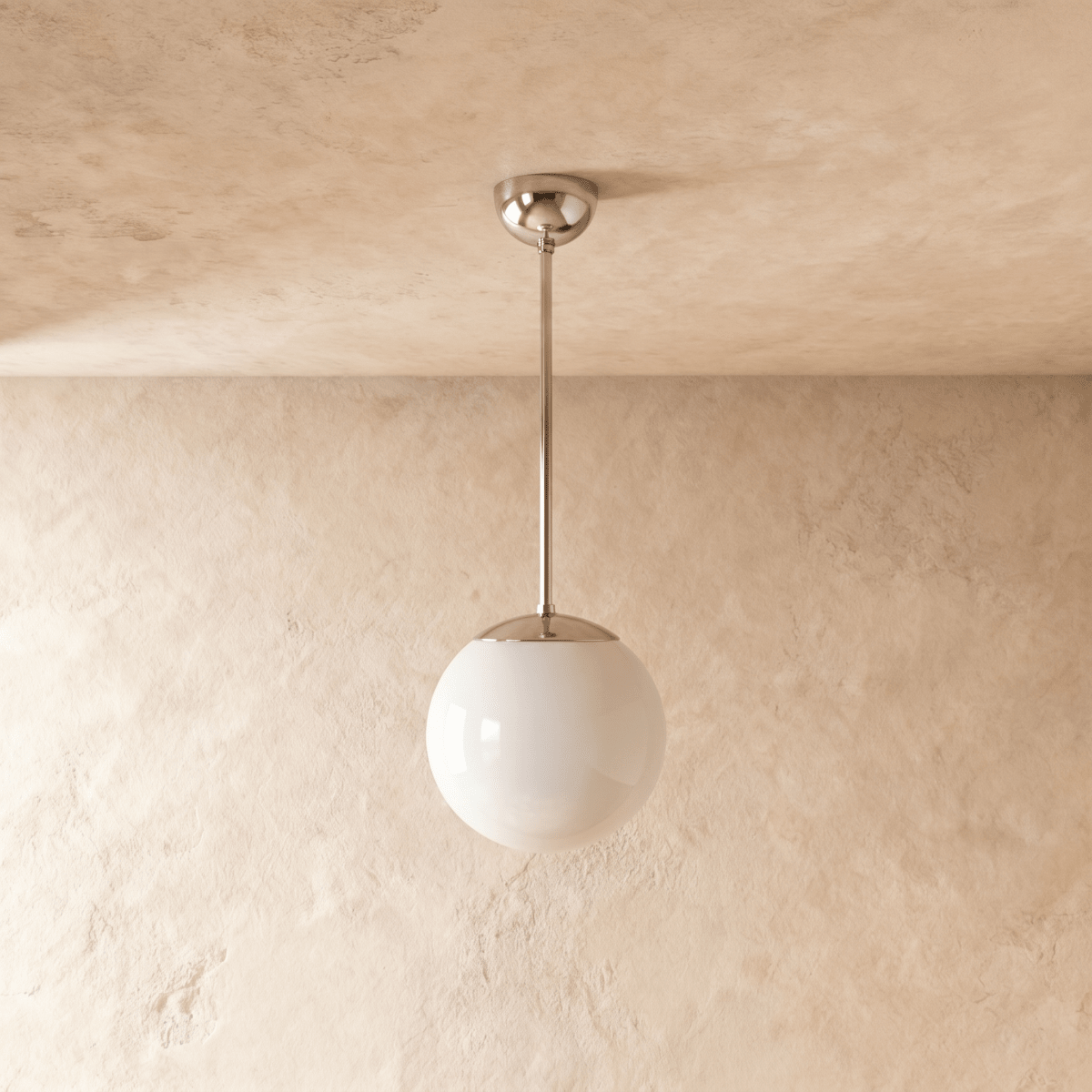 Clérachic globe pendant light in chrome, shown from a slightly closer studio angle against a plaster wall.