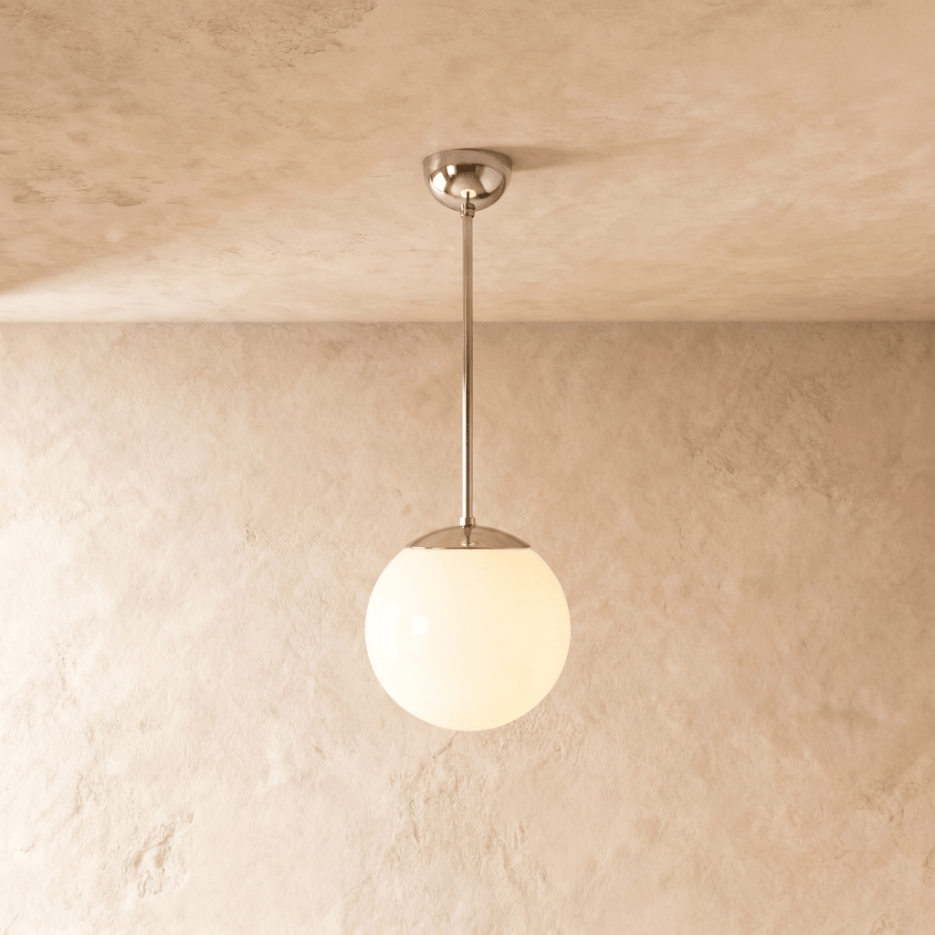 Clérachic globe pendant light in chrome, hung on a rod from a plaster ceiling and photographed in studio.