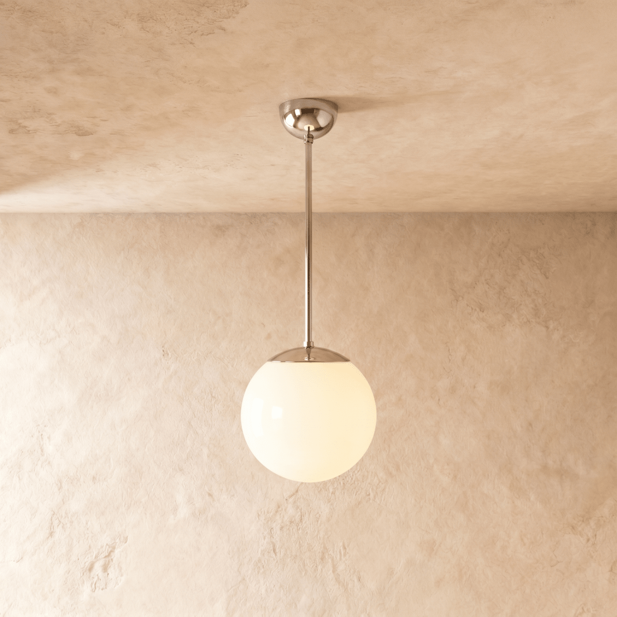 Clérachic globe pendant light in chrome, hung on a rod from a plaster ceiling and photographed in studio.