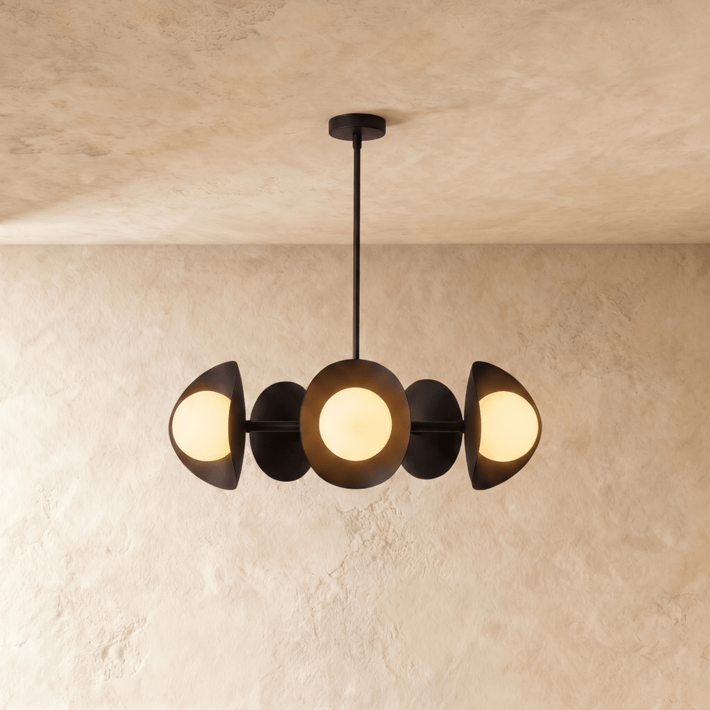 Clérachic chandelier in matte black, its row of overlapping discs and opal glass globes below a plaster ceiling.