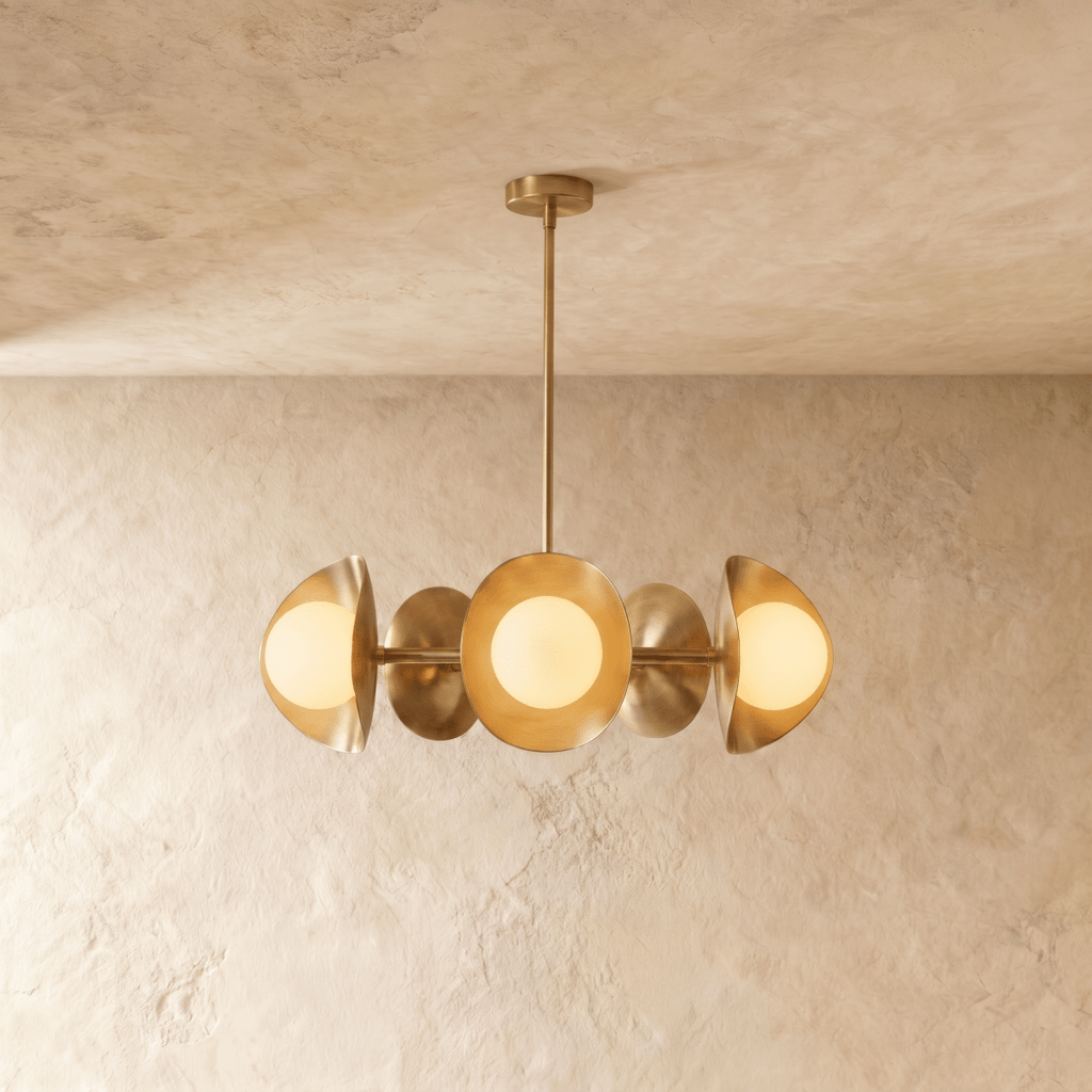 Clérachic chandelier in a brighter brass finish, its row of overlapping discs and opal globes below a ceiling.