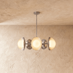 Clérachic chandelier in a bright chrome finish, its row of overlapping discs and opal globes below a ceiling.