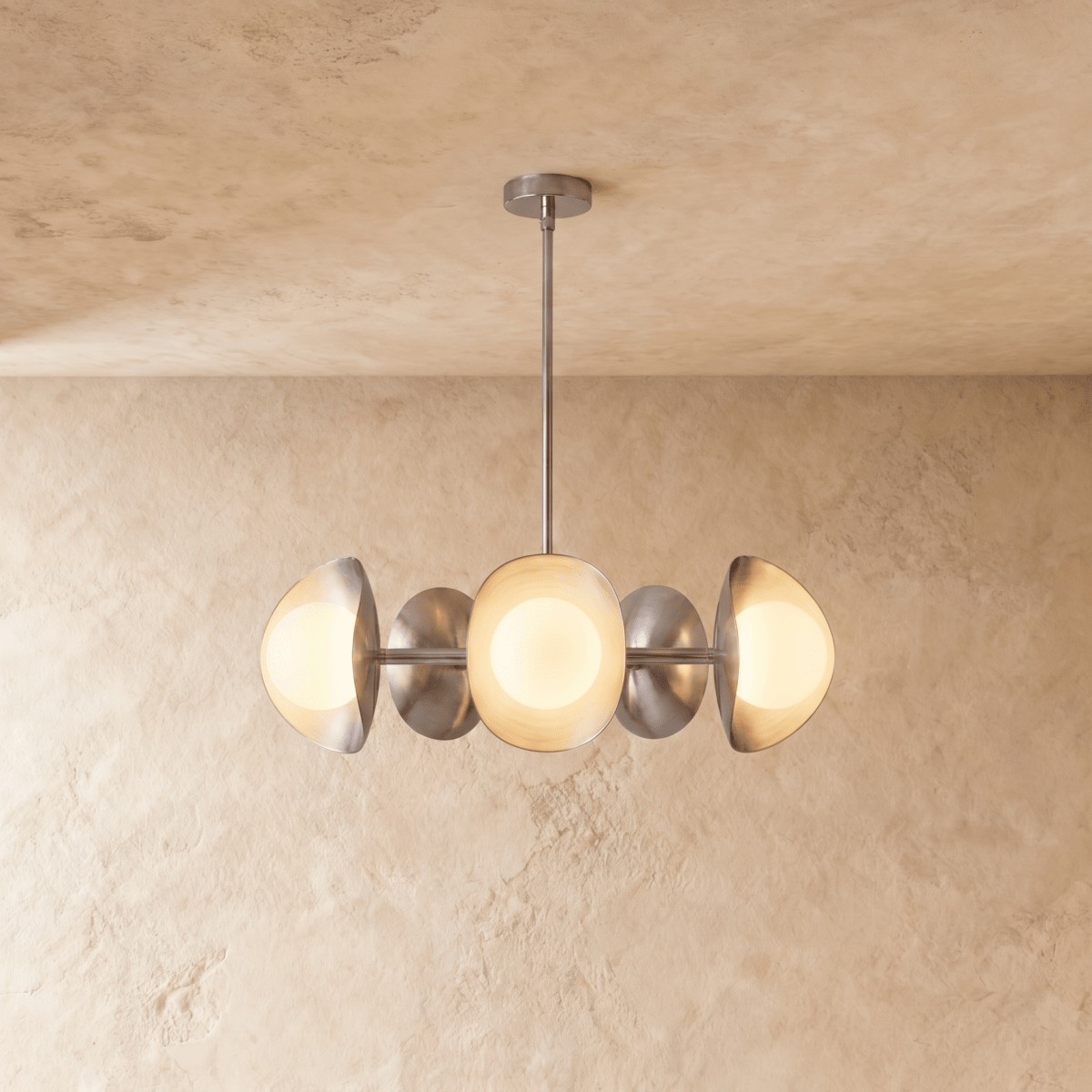 Clérachic chandelier in a bright chrome finish, its row of overlapping discs and opal globes below a ceiling.