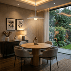 A chrome Clérachic pendant light lights a round table with garden views through floor-to-ceiling doors.