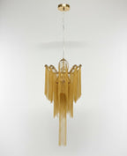 Its ceiling mount plate is visible above this lit gold Clérachic chandelier, shown against a white backdrop.