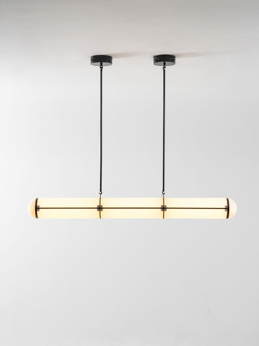 Linear pendant light suspended above a table