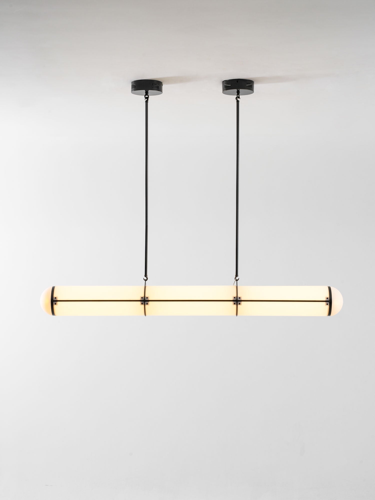 Linear pendant light suspended above a table