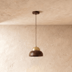 Clérachic pendant light unlit, showing the dark grain of the wood bowl and the metal dome seated on top of it.