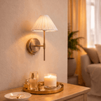This Clérachic wall light glows above a tray of candles and scent bottles on a bedside dresser.