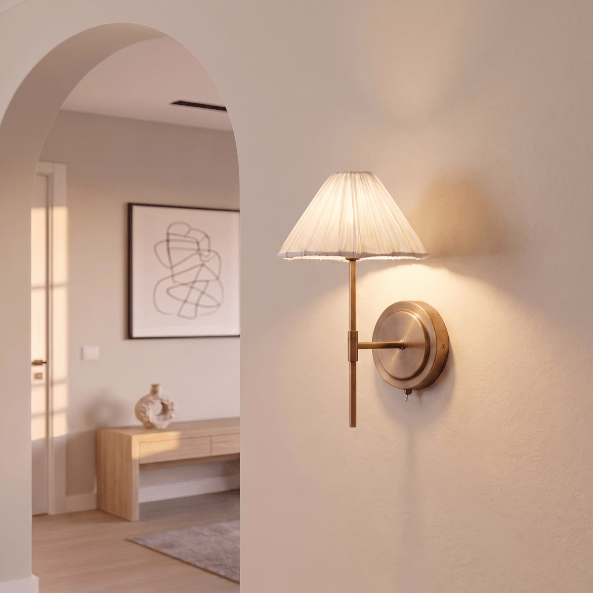 This Clérachic wall light glows softly beside an archway, its pleated shade lighting the plaster wall.