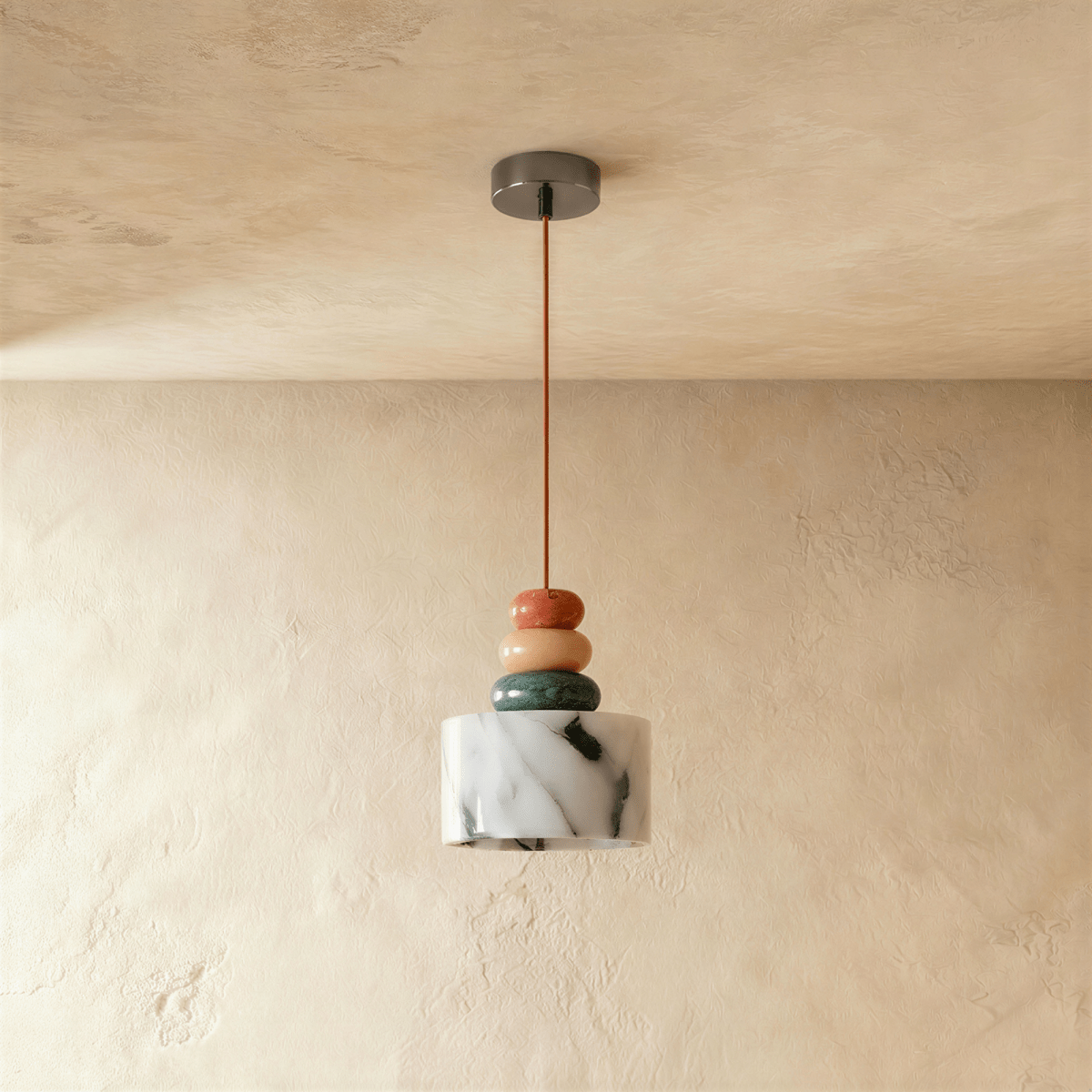 Clérachic stone pendant light switched off in a plaster-walled corner, showing the cool white shade and its grey-green veining under rust, tan and teal beads.