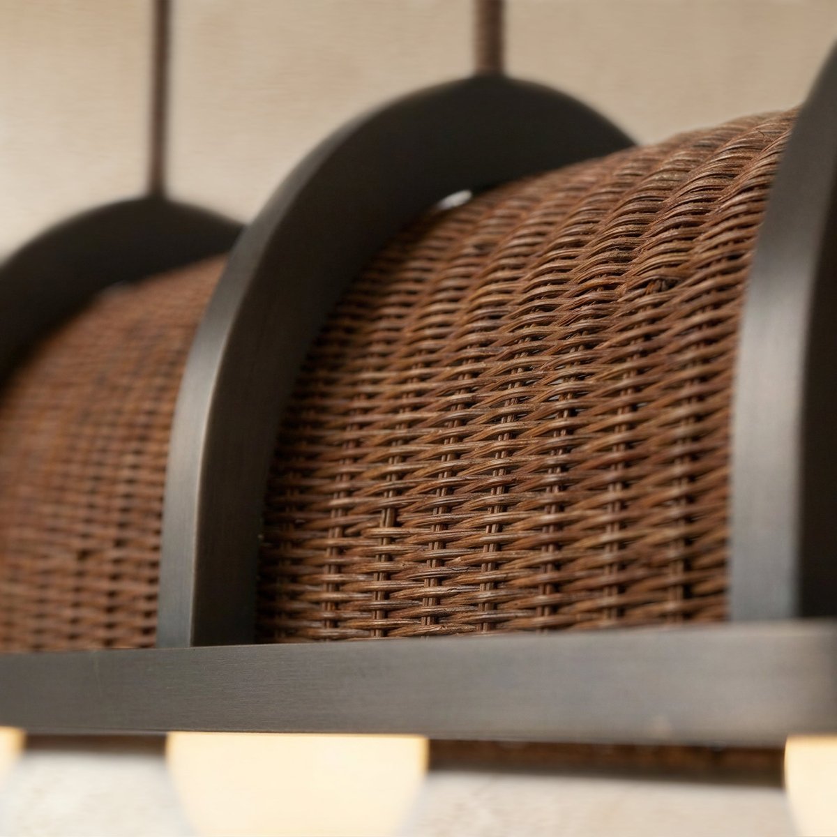 Clérachic Vetra rattan pendant light in detail, two woven domes rising either side of an arched metal divider above the flat rail.