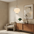 This Clérachic pendant light glows beside a sideboard styled with a green table lamp and framed art.