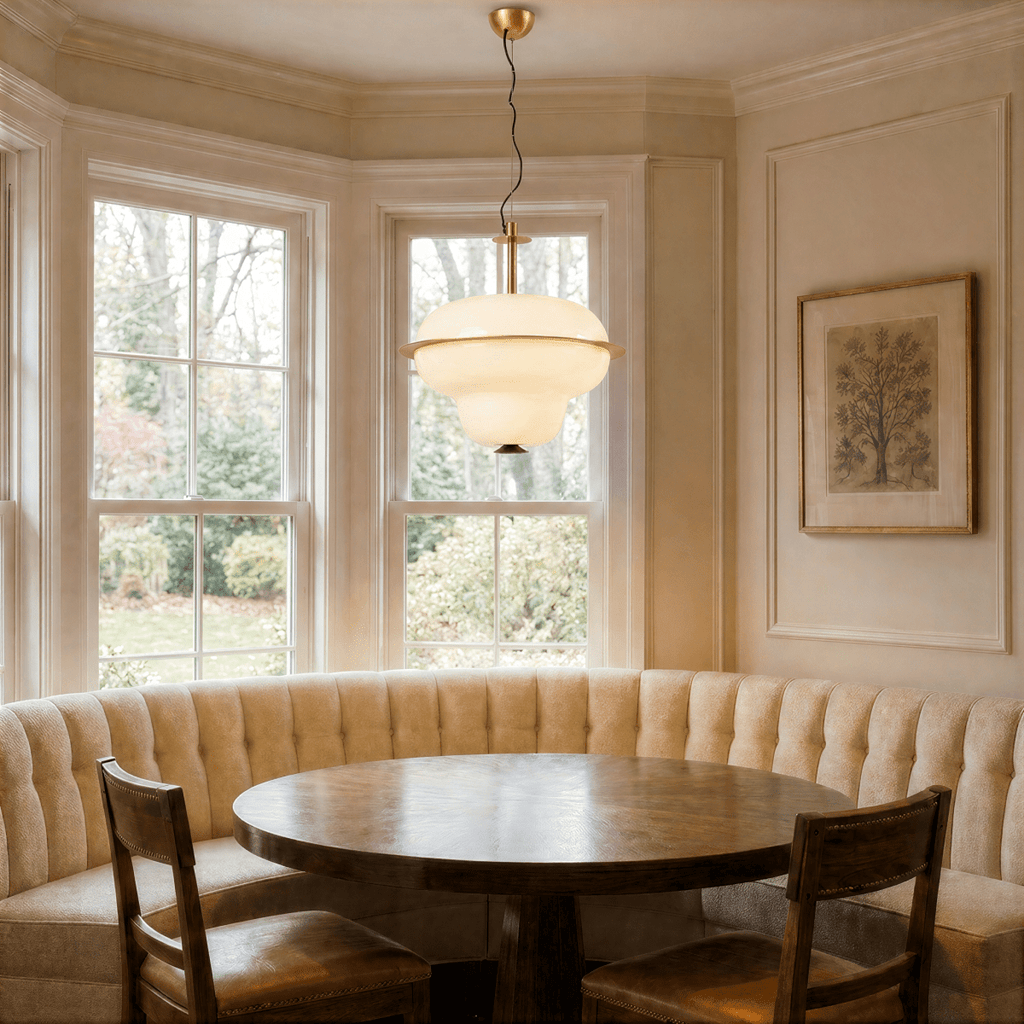 This Clérachic pendant light glows in a bay-window breakfast nook lined with tufted banquette seating.